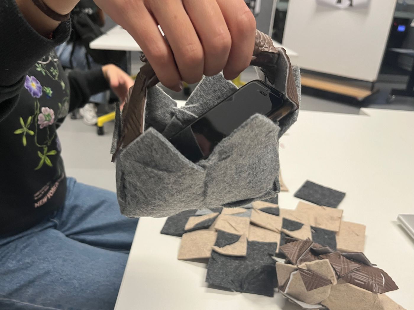 A small woven tile bag holding a phone, made during a workshop